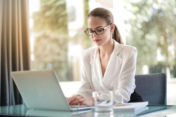 Confident businesswoman using a laptop at her desk, focused on her work.