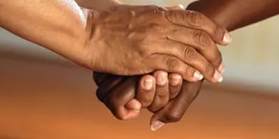 Two people holding hands in a gesture of support